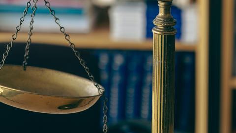 Close-up of scales of justice with a broken chain