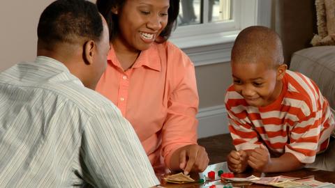 family playing Monopoly in a living room