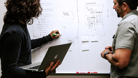 Two people working at a whiteboard