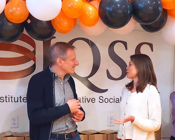 Gary King and Elizabeth Jackson chat in front of the IQSS banner