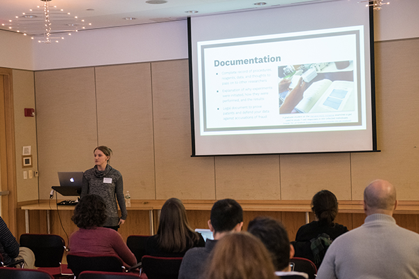 Conference speaker with projected presentation and audience