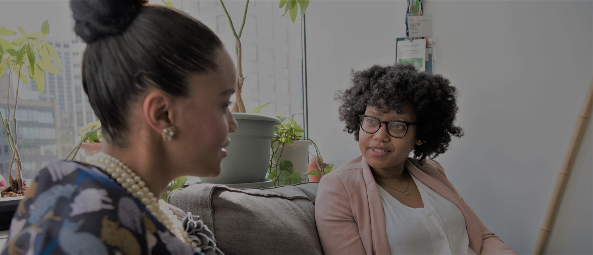Two people sitting on a couch in conversation