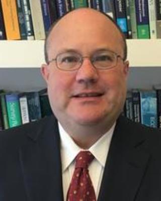 Chase Harrison in front of bookshelves