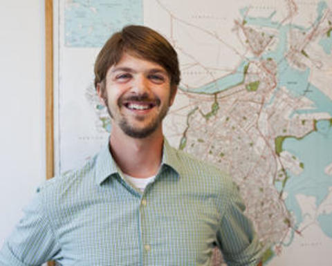 Dan O'Brien in front of a wall-mounted map of boston